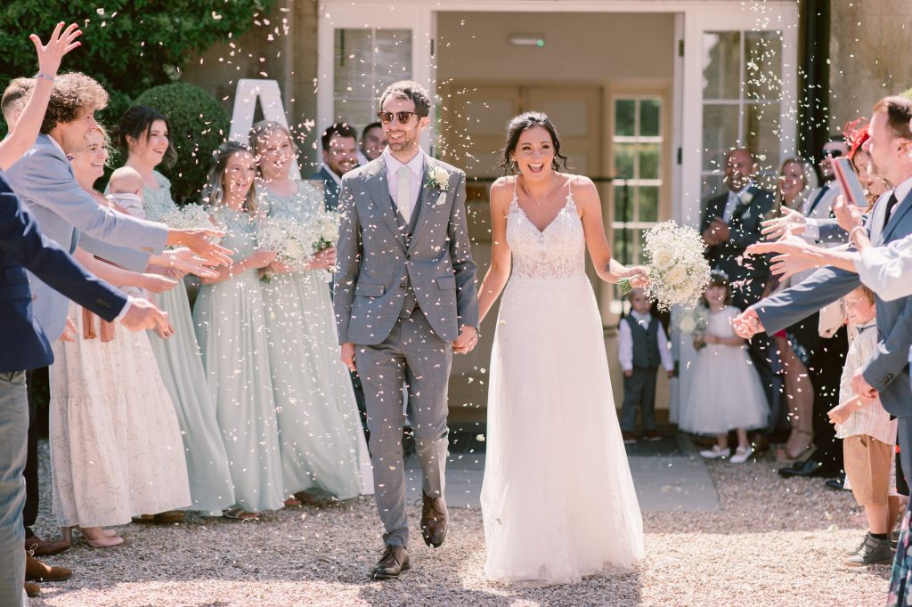 Bride and groom confetti walk through guests