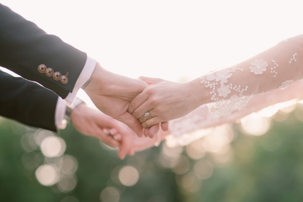 Bride & Groom holding hands, close up shot - 5 Tips for Dealing with Wedding Planning Opinions