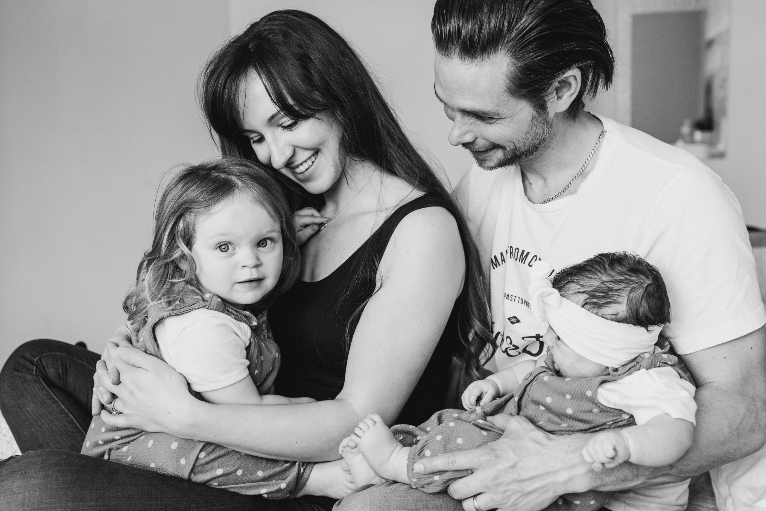 Black and white Family Photography - Hampshire Family photographer Hampshire Family photographer close up Black and white photo of Family sat on the bed looking at each other