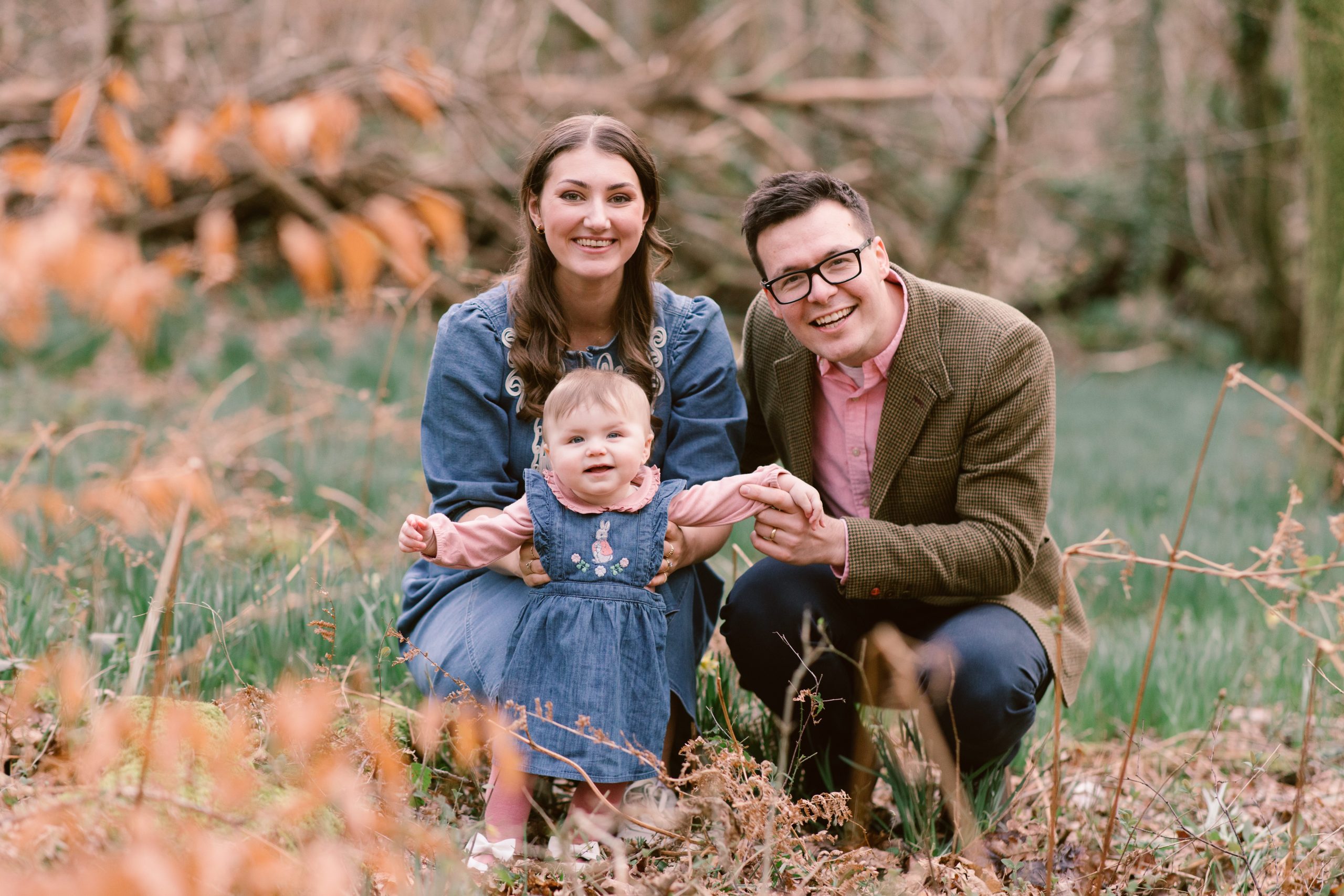 Family photography in 100 Acre Woods Hampshire Family photographer - Young family all smiling at the camera in 100 Acre Woods