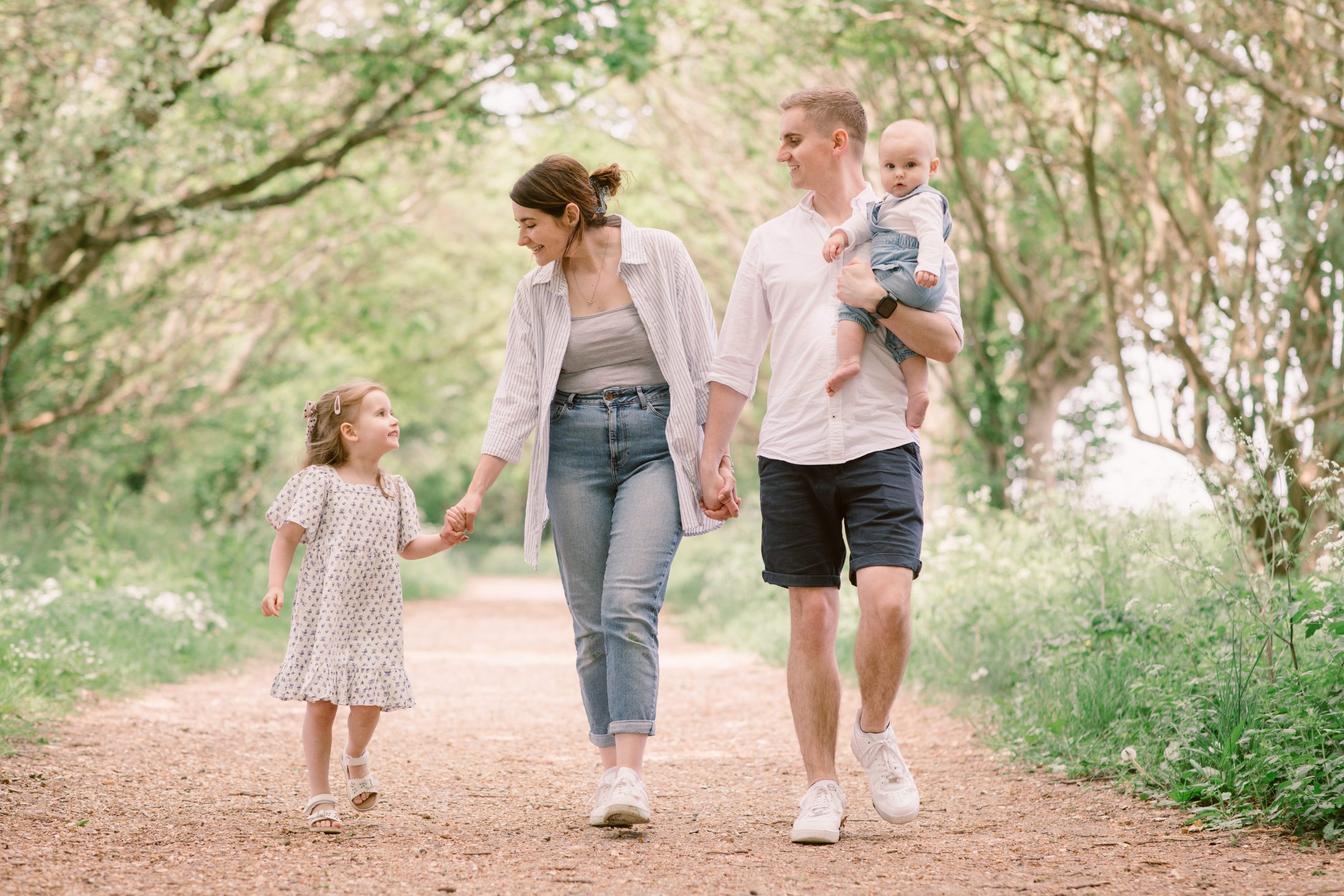 Hampshire Family photography Bluebell photos Hampshire Family photographer - Young Family walking together through the woods and looking at each other
